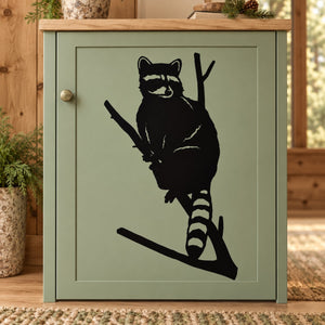 Black raccoon silhouette decal with raccoon perched on a diagonal branch