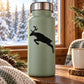 Sage green bottle with black leaping reindeer decal on front