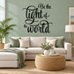 Black script wall decal reading 'Be the light of the world'