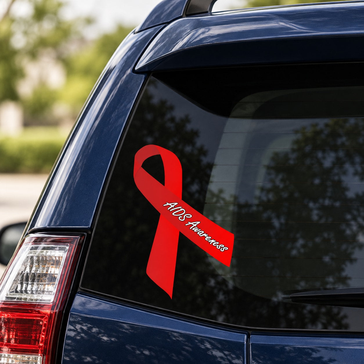 Red AIDS awareness ribbon vinyl sticker on a car window