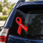 Red AIDS awareness ribbon vinyl sticker on a car window