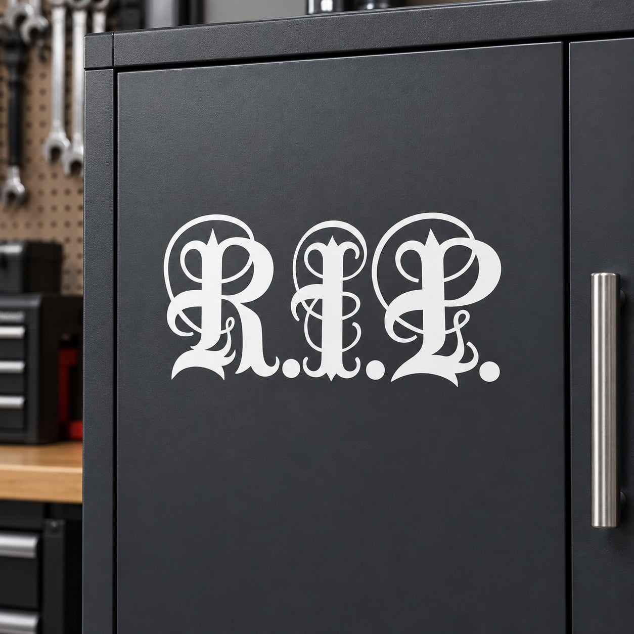 Calligraphic RIP decal with white ornate lettering on dark surface