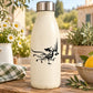 Black rooster decal with flowing feathers on a white bottle