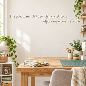 Wall decal with cursive quote: “Snapshots are stills of life in motion”