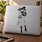 Intrigued warrior woman decal in black line art on a light-colored laptop
