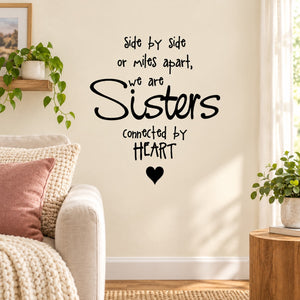 Wall decal with black text: "Sisters" connected by heart, plus small heart icon