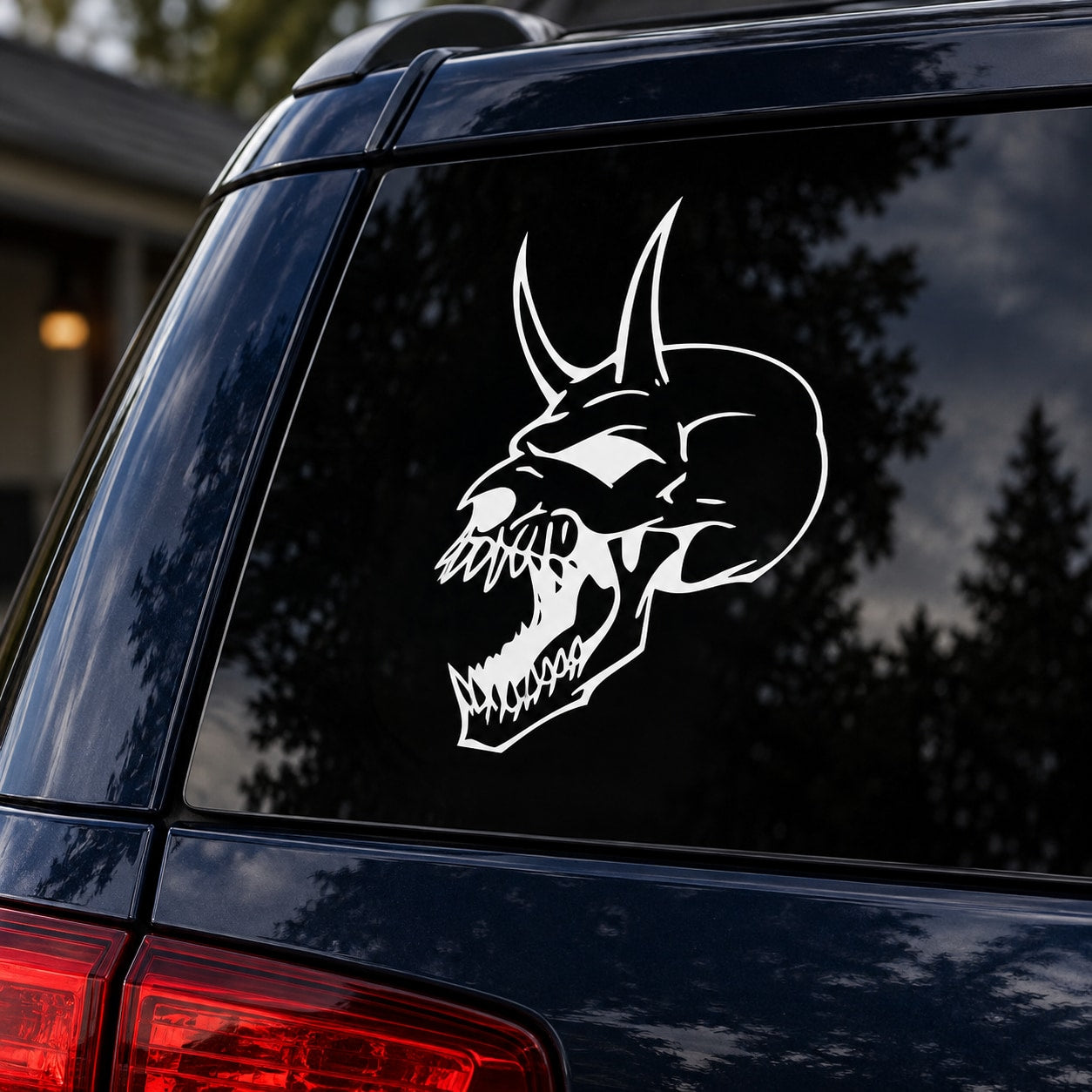 White skull head vinyl decal with devil horns on a car window
