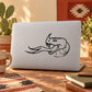 Horned snake head hissing decal in black outline on light laptop lid
