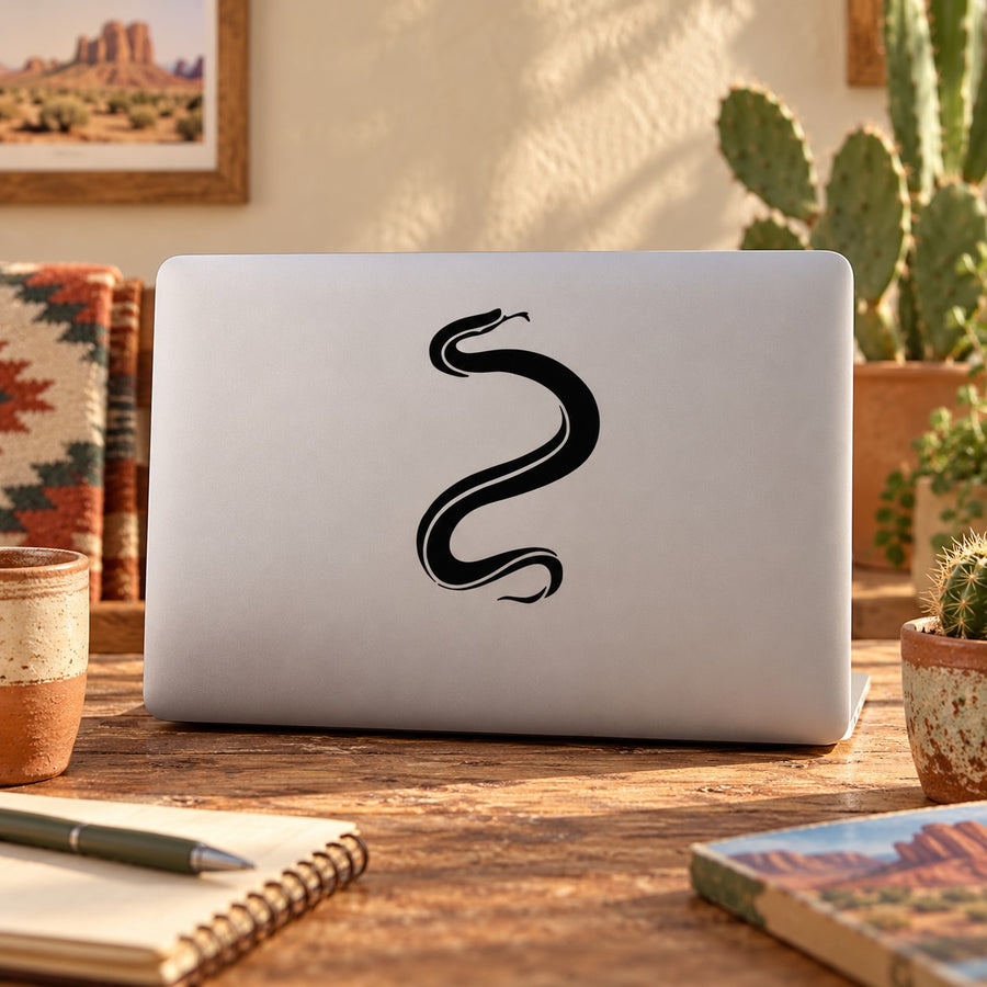 Black outline snake decal on light laptop lid