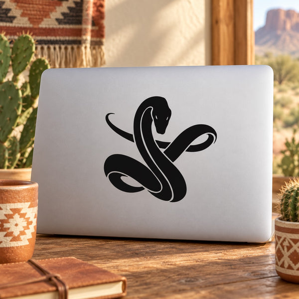 Black snake decal with curled tail on light laptop lid