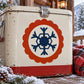 Snowflake sticker with blue geometric snowflake in orange scalloped circle