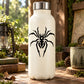 Alien spider decal on white bottle: black arachnid web graphic