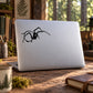 Black spider line-art decal on laptop lid