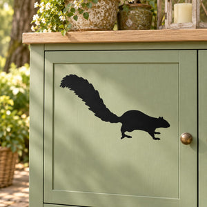 Black squirrel silhouette decal for indoor decor on a light green cabinet door.