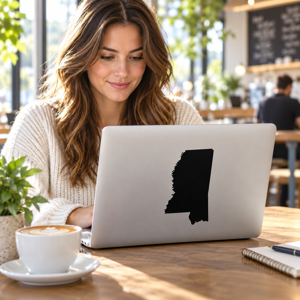 Mississippi state decal on laptop lid, black outline of state shape