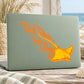 Flaming stingray sticker with orange graphic on light green laptop lid