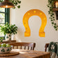 Gold horseshoe St Patrick's Day sticker with small circular holes