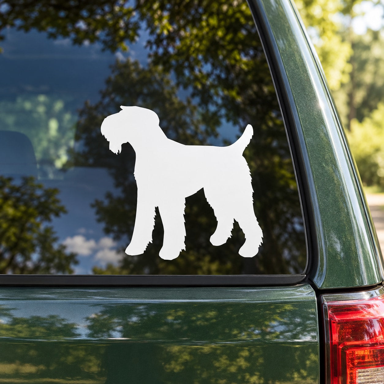 White Airedale terrier decal sticker with silhouetted dog on car window.