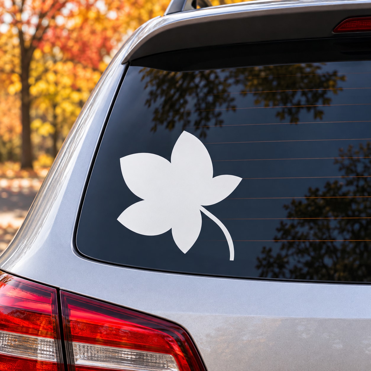 White leaf-shaped decal on car rear side window