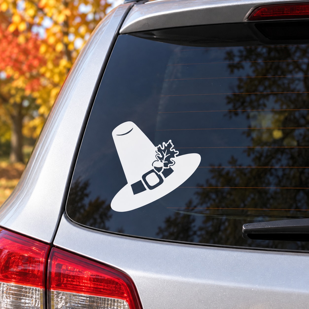 White pilgrim hat Thanksgiving decal on car window glass with leaf-style accent