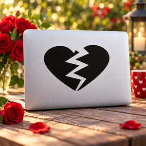 Black broken-heart decal with jagged crack design on white laptop lid