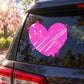 Pink graffiti heart sticker on dark vehicle window