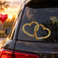Double-heart Valentine's Day car decal with gold glitter outline on a dark window