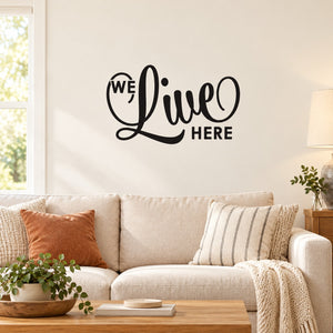 Black "We Live Here" wall decal with bold hand-lettered typography