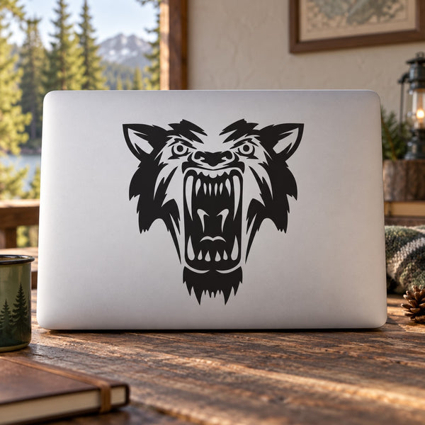 Laptop with black wolf head decal showing teeth