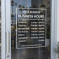Framed business hours decal with white text and hours for Monday–Sunday on glass
