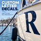 Large white letter R decal on a shiny boat surface