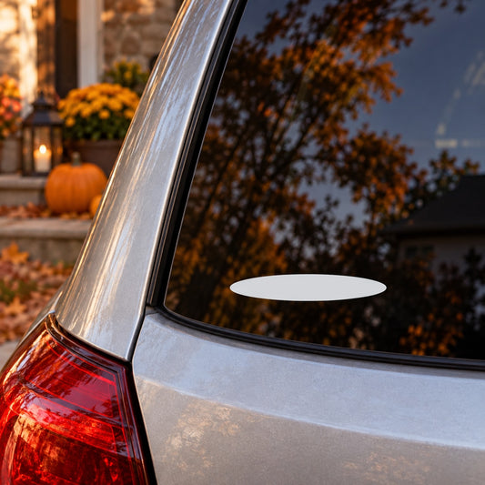 White oval vinyl decal on car rear window glass near taillight