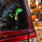 Frankenstein character sticker on window: green monster with black coat and yellow scarf