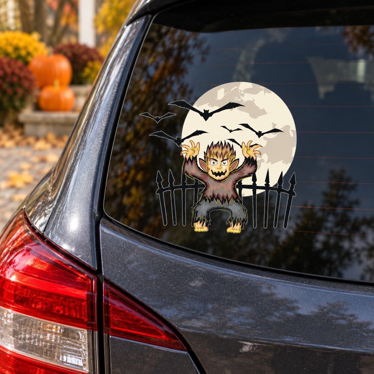 Werewolf sticker on car rear window with bats above and fence behind