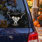 Mummy bat character sticker on blue car window, black wings and wrapped white body