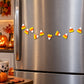 Candy corn magnets scattered on a stainless steel refrigerator door