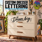 Wooden dresser with three drawers and 'Dream big' front text