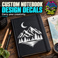 Black hardcover notebook with moon and mountain illustration on front.