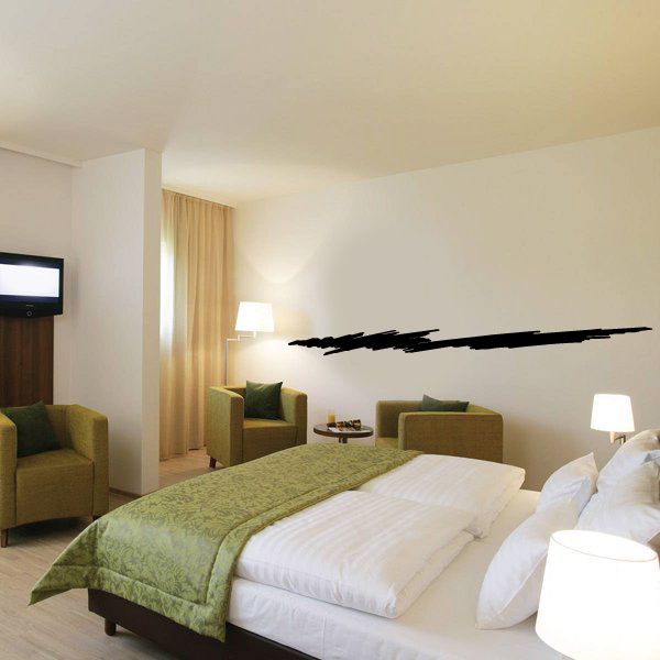 Black pinstripe vinyl decal strip on wall, long sweeping line above bedroom bed.