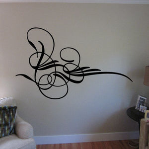 Black vehicle pinstripe vinyl decal with swirls and circles on a wall