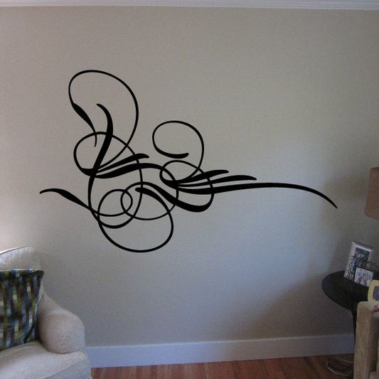 Black vehicle pinstripe vinyl decal with swirls and circles on a wall