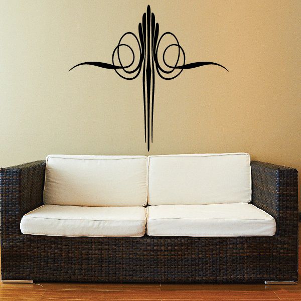Pinstripe vinyl car decal cross with swirling flourishes, black on light wall