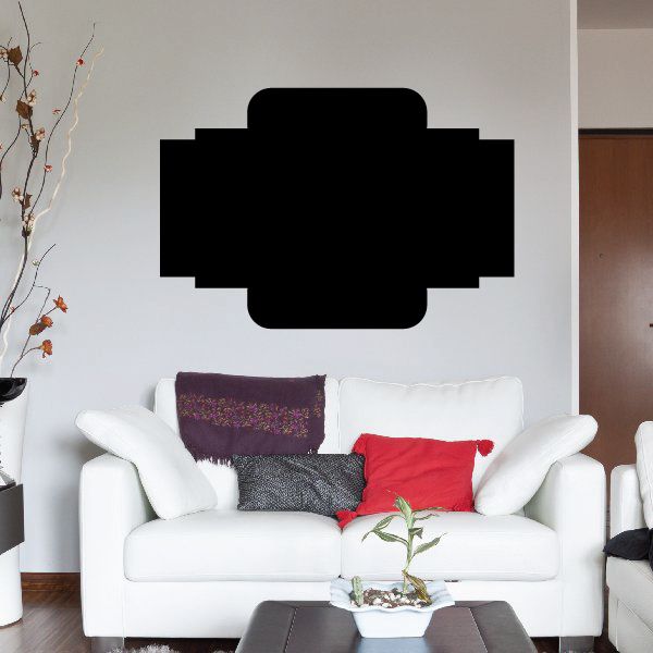 Black vinyl wall decal with cross-shaped center panel above sofa