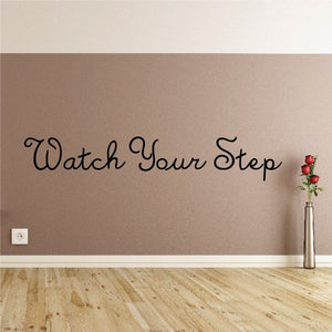 Wall decal: Watch Your Step with cursive lettering and red flower accents