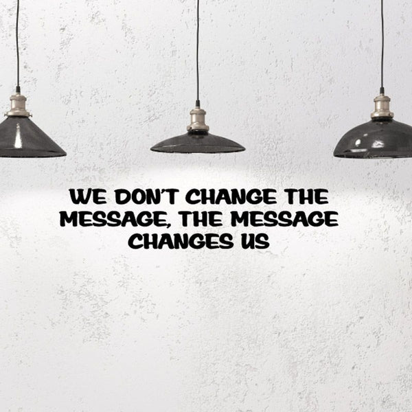 Wall decal with bold black quote: 'WE DON'T CHANGE THE MESSAGE, THE MESSAGE CHANGES US'