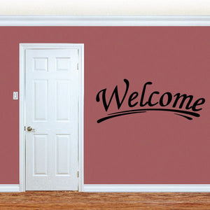 Welcome wall decal with black cursive text on a flat surface