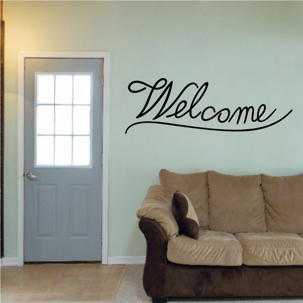 Welcome wall decal in black cursive lettering on light wall