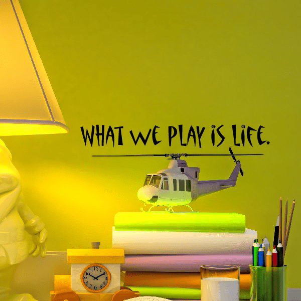 Wall decal with bold text “WHAT WE PLAY IS LIFE.” and small airplane icon