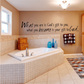 Wall decal with inspirational quote in black script on beige wall above sink