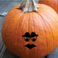 Witchy face pumpkin decal with black eyes, eyebrows, and bat-like mouth on orange pumpkin